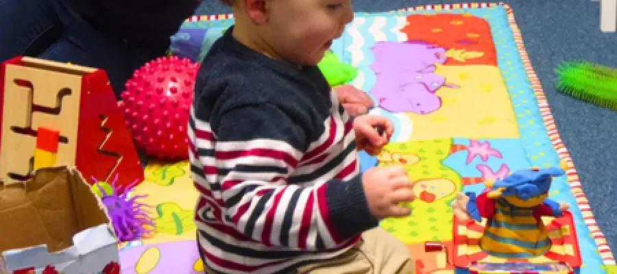 Child on playmat with toys