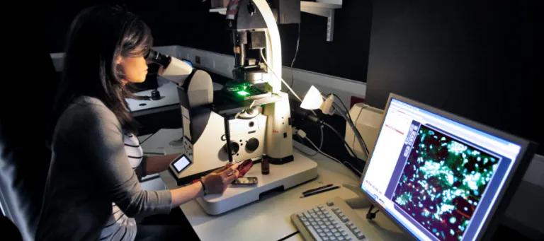 student with microscope