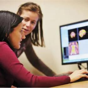 Photograph of researchers analysing human brain MRI scans