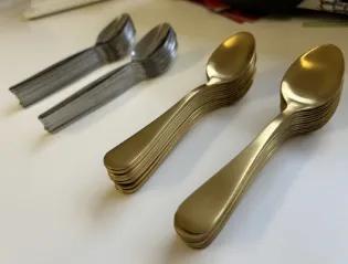 stacked golden and silver spoons
