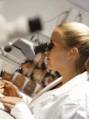 Photograph of female scientist using a microscope