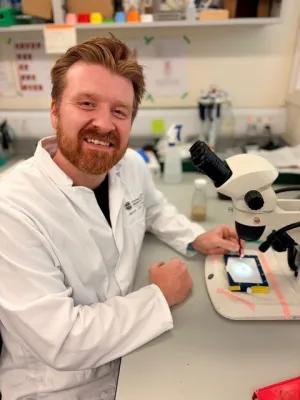 man with beard with microscope